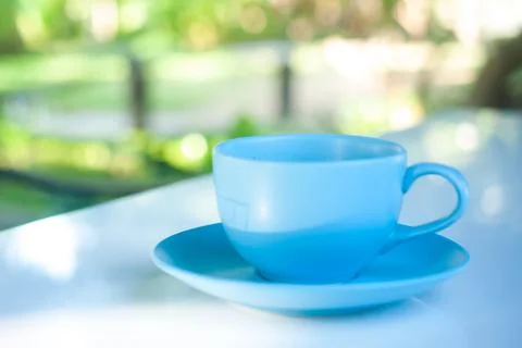 Blue cozy coffee cup on white table and natural background Stock Photos