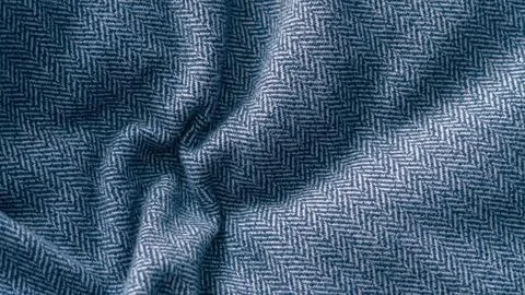 Blue crumpled herringbone fabric texture close up Stock Photos