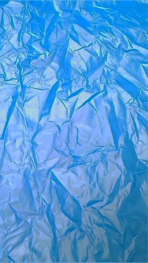 Blue crumpled plastic bag texture background rotating. HDPE Polyethylene Stock Footage 316377319