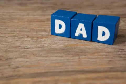 Blue cube shapes with dad text on wooden table Stock Photos