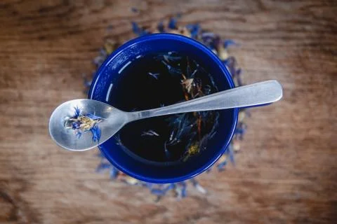 Blue cup and spoon with flowered black tea on a wooden background. Breakfast, Stock Photos