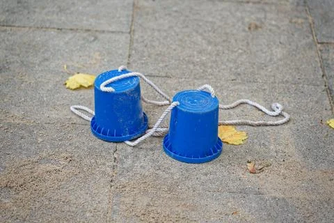 Blue cup string telephone on pavement symbolizing simple communication and .. Stock Photos