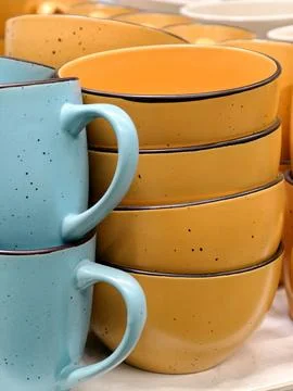 Blue cups and yellow deep ceramic plates displayed in grocery store shelvin.. Foto stock