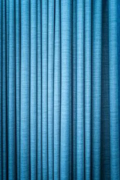 Blue curtain in folds. textured background. Stock Photos