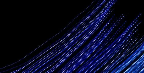 Blue dashed lines of lights on a black background Stock Photos