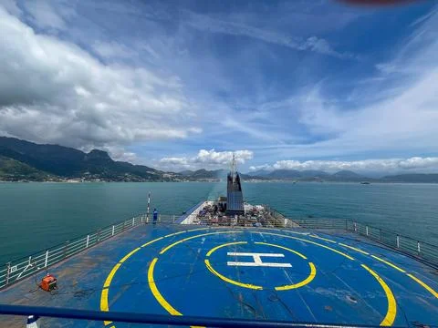 Blue deck of a large ferry ship with a yellow helipad sign sailing on the sea Stock Photos