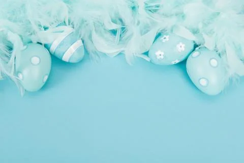 Blue decoration easter eggs and blue feathers on a blue background Foto stock