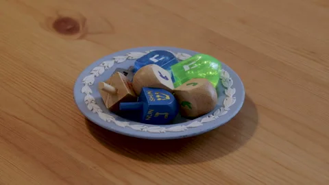 Blue decorative bowl of dreidels on table Stock Footage 295922115