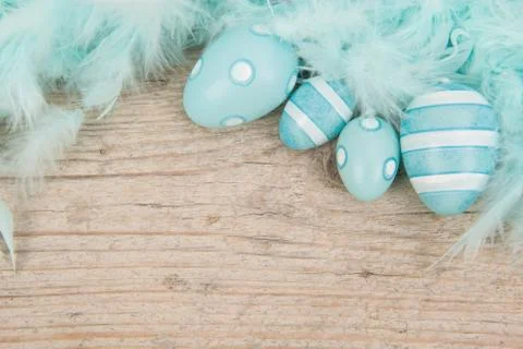 Blue decrorative feathers and easter eggs on a wooden background Stock Photos