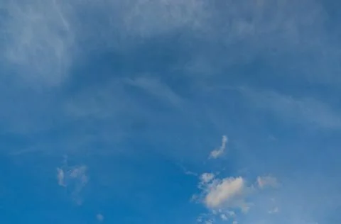 Blue deep sky with a few clouds illuminated by the setting sun. Foto stock