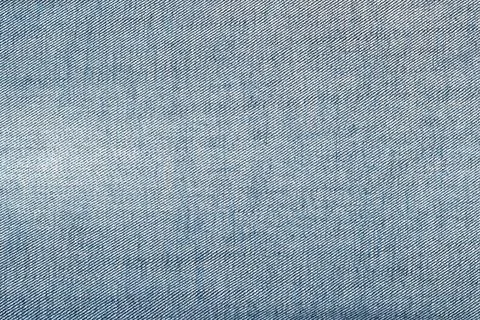 Blue denim fabric texture with diagonal weave pattern and soft lighting 写真素材