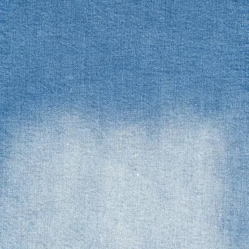 Blue denim fabric texture surface. Faded jeans material with gradient patte.. Stock Photos