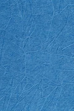 Blue denim fabric texture with visible weave and crease marks. Durable text.. Stock Photos