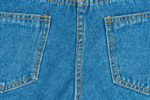 Blue denim jeans texture with back pockets and orange stitching closeup Stock Photos
