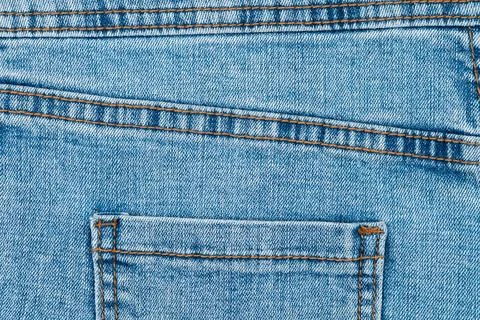 Blue denim jeans texture with back pocket and orange stitching Stock Photos