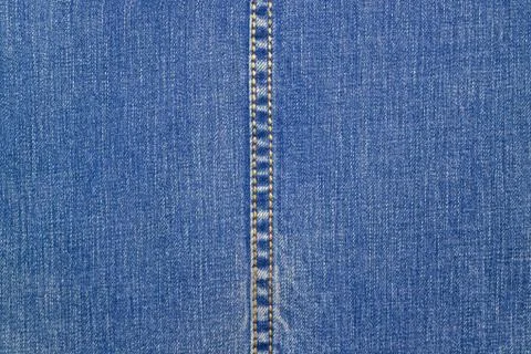 Blue denim with a vertical seam in the middle. Fabric blue background Stock Photos