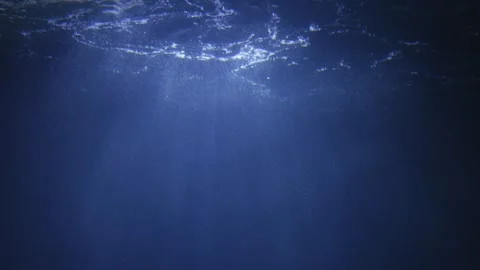 Blue depths with light beams illuminating floating bubbles and particles. L.. Stock Footage 293053773