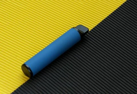 Blue disposable electronic cigarette isolated on bright yellow background Stock Photos