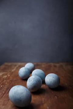 Blue diy painted easter eggs on brown wooden rustic table, grey background Stock Photos
