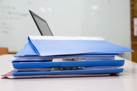 Blue Document folder on table at office with laptop background Photos