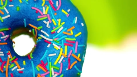 Blue donut with colored sprinkles rotates on a green background copy space 動画素材 130758577