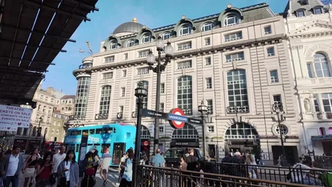 Blue double decker bus passes the London underground sign at Piccadilly Circus Stock Footage 314398514