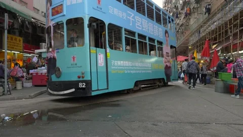 A blue double-decker bus passing by on a crowded street Stock Footage 146587370