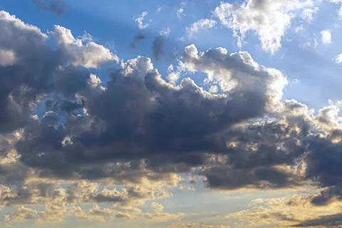 Blue dramatic sky background - picturesque bright clouds lit by sunlight. Vas Stock Photos