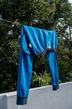 Blue draw string pants hanging on a wire in an Indian house hold on a roof to Foto stock