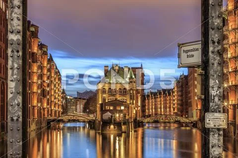 Blue dusk and lights are reflected in Poggenmohlenbrucke with water castle Stock Photos