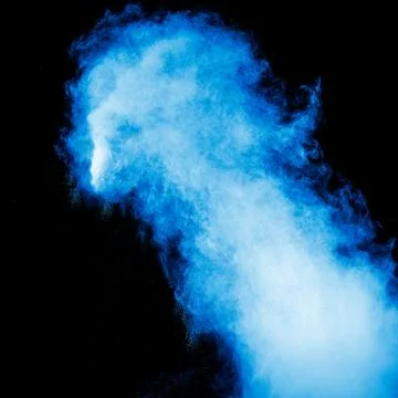 Blue dust explosion on black background. Freeze motion of color powder splash Stock Photos