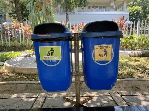Blue dustbin with different type or rubbish in the walking path 库存照片