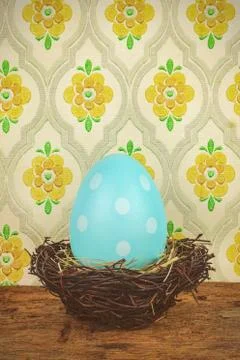 Blue dyed big easter egg in a bird nest on a wooden table Foto stock