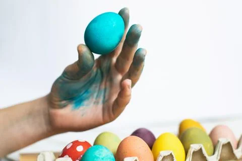 Blue Easter egg in hand on white background. Painting Easter eggs Stock Photos