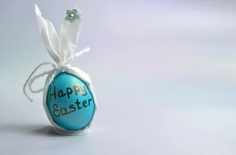 Blue Easter egg with an inscription on a gray background. Happy Easter. Stock Photos