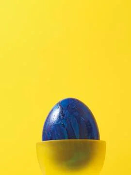 Blue Easter Egg in Yellow Eggcup Stock Photos