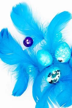 Blue Easter eggs and small fluffy blue feathers randomly scattered Stock Photos