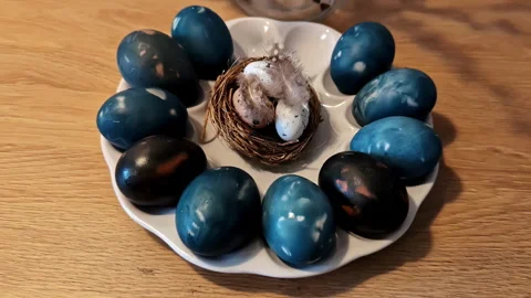 Blue Easter eggs arranged in a circular pattern with a bird nest centerpiece 库存影片 302368517