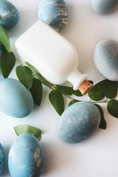 Blue Easter eggs, Decorated with garland of green leaves, vertical image Stock Photos