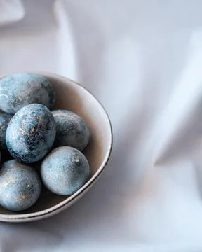 Blue easter eggs in grey plate, monochrome picture with copy paste. Stock Photos