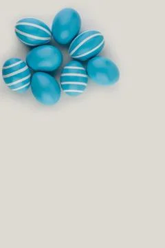 Blue Easter striped eggs on a white. Copy space. Top view. Stock Photos