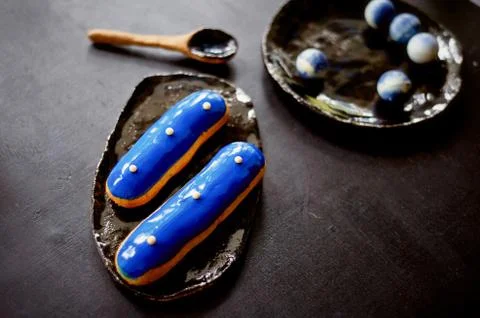 Blue eclairs and candy in blue colors.On a dark background. Pastry arts Stock Photos