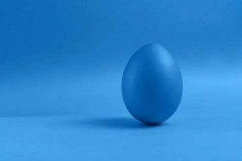 Blue egg on blue background Stock Photos