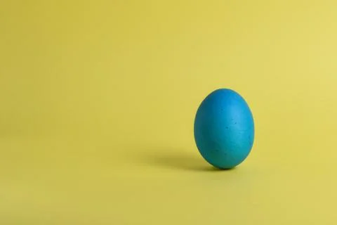 Blue egg on yellow background Stock Photos