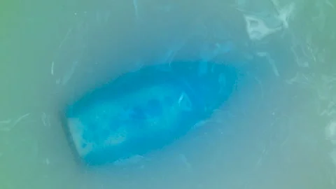 Blue elixir bottle pulled from the water Stock Footage 93314853