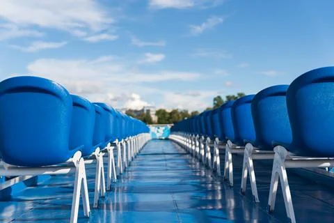 Blue empty plastic chairs on a river cruise ship Stock Photos