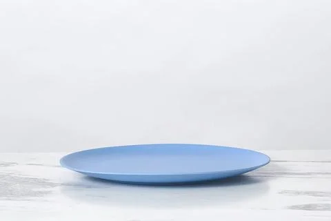 Blue empty plate on marble table, white background, copy space Stock Photos