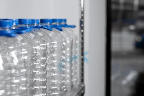 Blue empty water bottles on a shelf in a store. Place for text Stock Photos