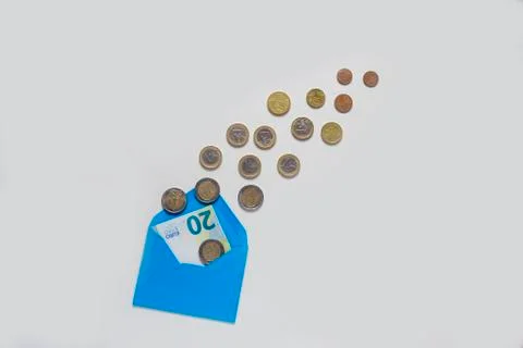 Blue envelope on a light background. A lot of coins, different denominations. Stock Photos
