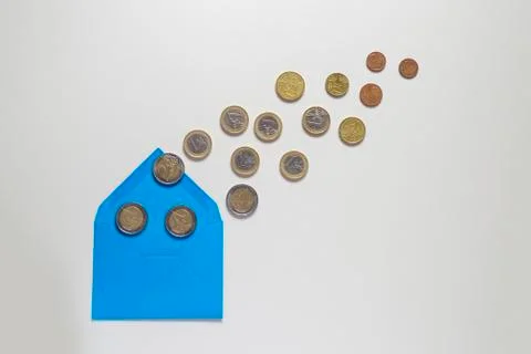 Blue envelope on a light background. There are a lot of coins, various denomi Stock Photos